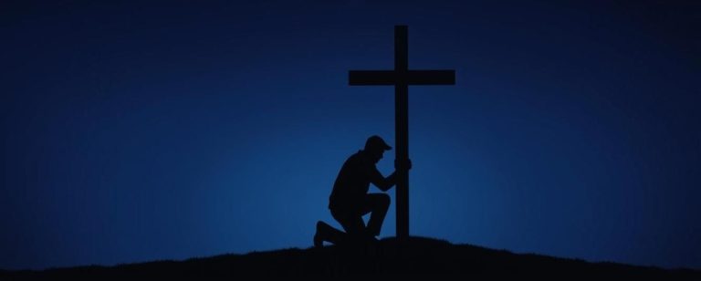 The silhouette outline of a man kneeling before a cross